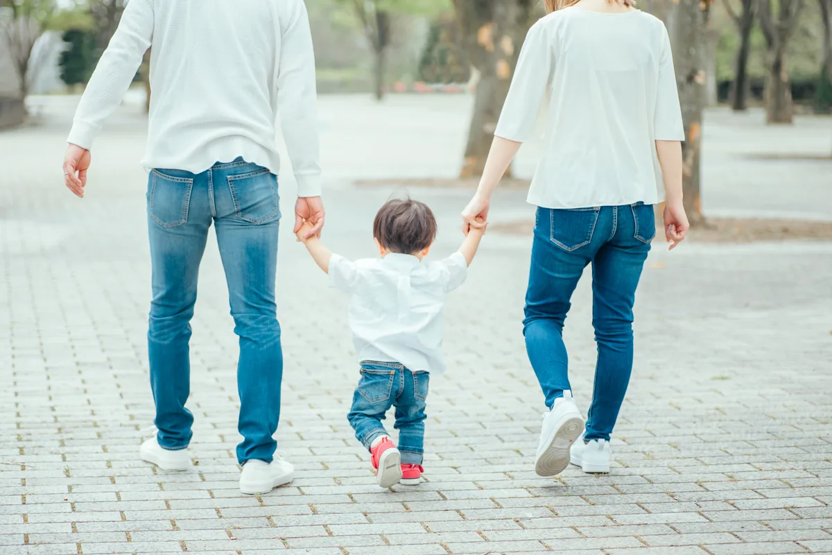 手をつないで歩く親子の後ろ姿