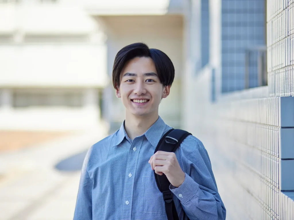 笑顔で立つ若手社員(イメージ)